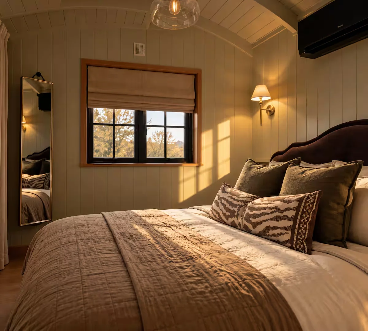 Sloe's king-size bed beside the bedroom window and warm bedside lighting